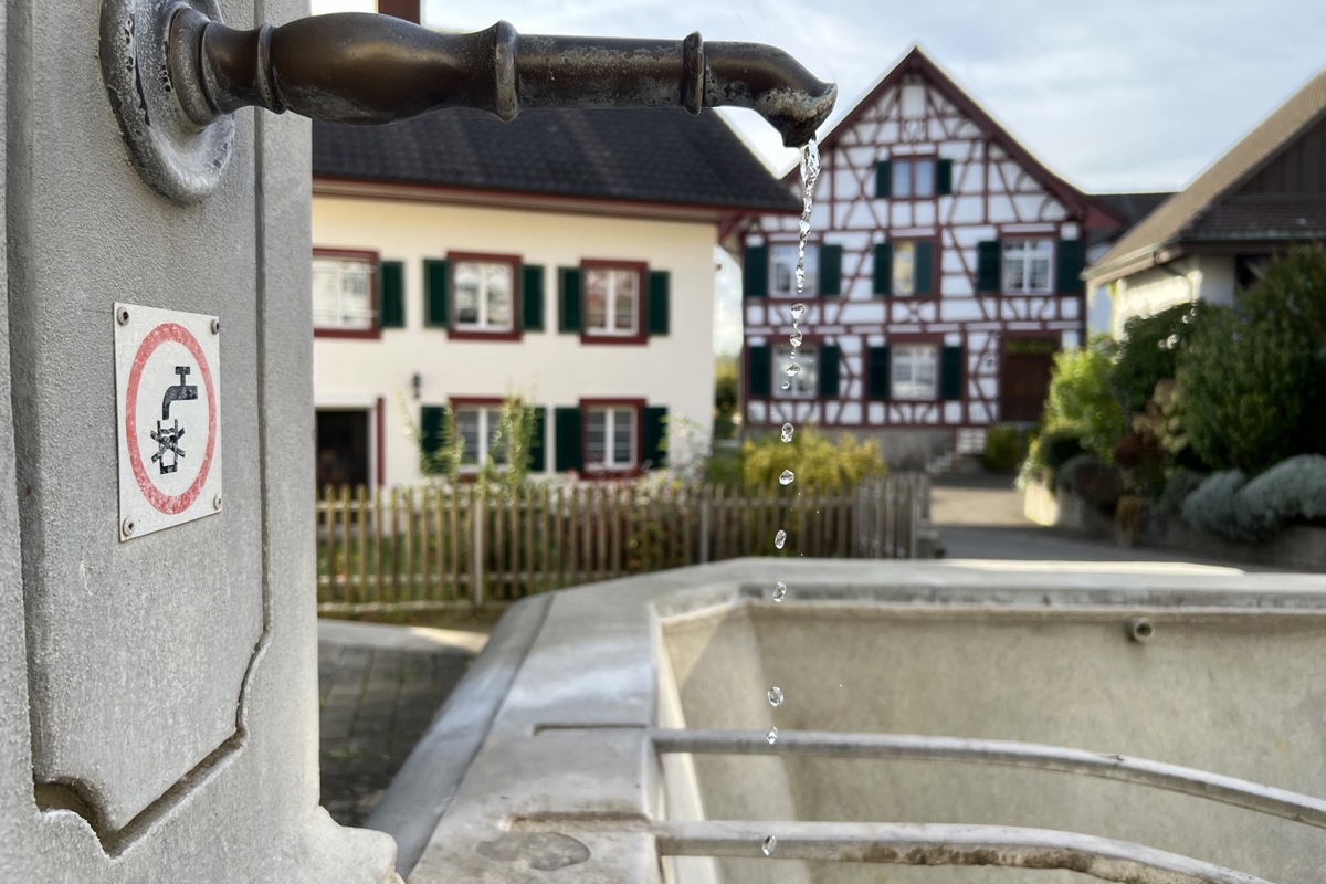 In Uhwiesen (im Hintergrund das Gemeindehaus) fliesst – oder tröpfelt – Quellwasser aus Laufbrunnen.