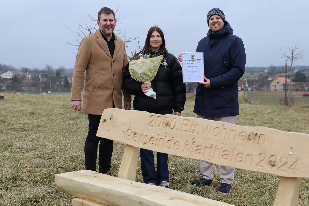 Eine Bank für die 2000. Einwohnerin, Nadine Wyler, flankiert von Matthias Stutz und Roger Fankhauser.