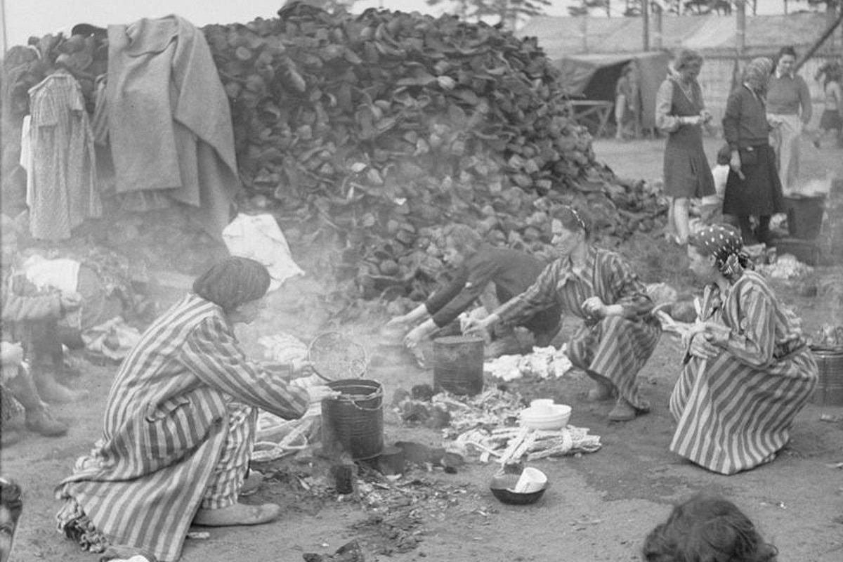 Die aufgestapelten Schuhe der Toten werden als Brennmaterial verwendet. Das Foto stammt von britischen Soldaten. Es wurde unmittelbar nach der Befreiung des KZ im April 1945 aufgenommen.