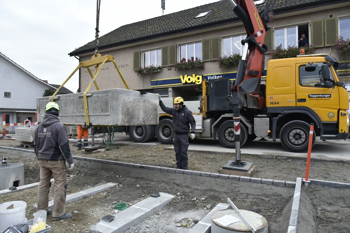 Mit Hilfe des Kranwagens schwebt der grosse Brunnentrog von 1924 an seinen neuen Standort.