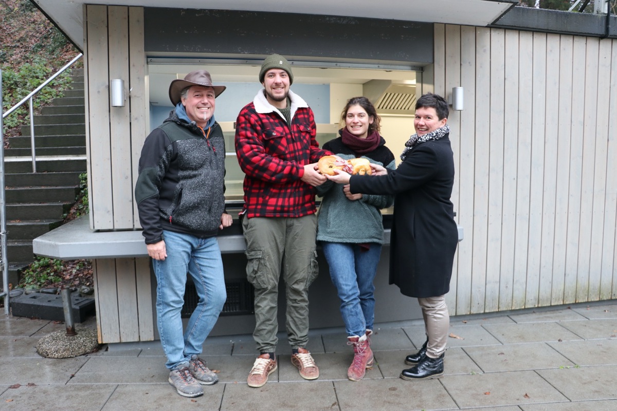 Gemeinderätin Irène Brühlmeier (r.) überreicht dem neuen Pächterpaar Rick Odermatt und Michelle Murri feierlich den «Schlüssel» zur Badi Bachdelle. Bademeister Beat Wüthrich (l.) freut sich auf die Zusammenarbeit.