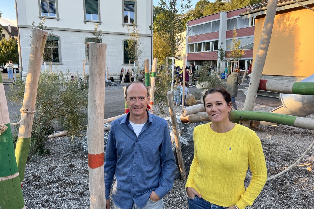 Schulpräsident Michael Hochstrasser und Schulleiterin Susan Grötchen in der Aussenanlage, die für eine halbe Million Franken erneuert wurde. Hinten links das renovierte Gebäude.