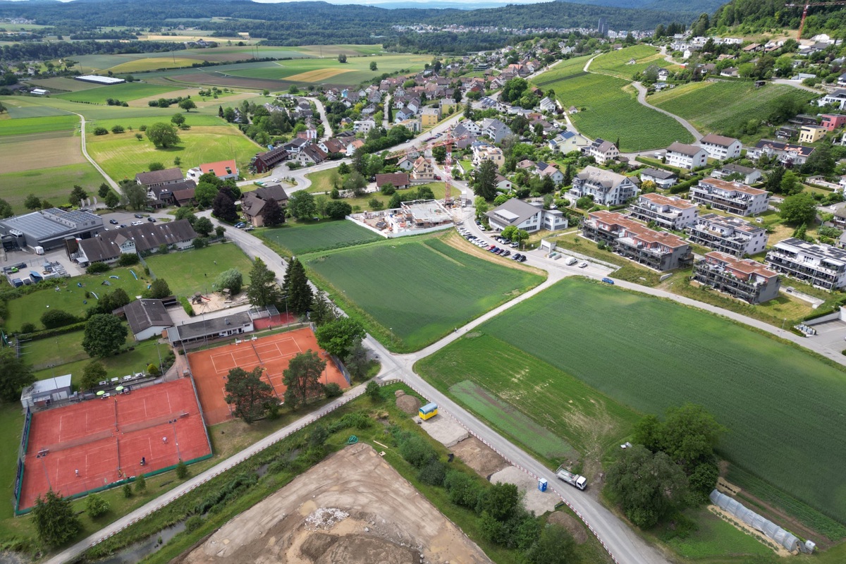 Uhwiesen baut und plant. Das Gebiet Hofacker zwischen Tennisplatz und Quartier bietet Platz für Wohnen und Arbeiten. Aktuell entsteht der Spiel- und Begegnungsplatz (Bildrand unten), das Werkgebäude (links im Bild) wird saniert.