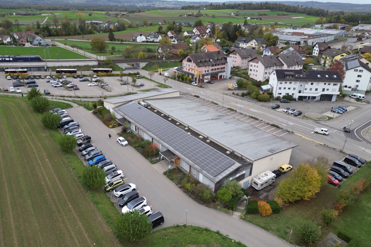 Ein Zentrum, drei Dächer: Dem Bahnhof zugeneigt ist der Gebäudeteil mit dem Theorieraum, der bestehen bleibt. In dem Teil links mit Photovoltaik-Anlage könnte sich künftig die Arztpraxis auf der ganzen Länge ausbreiten. Denn die Physiotherapie soll in ein neues Obergeschoss über der Feuerwehrhalle ziehen. Letztere (rechts) hat ein stark sanierungsbedürftiges Dach, das der Auslöser für das Projekt ist. Vorgesehen ist zudem, den Parkplatz im Vordergrund zu verbreitern, damit auf beiden Seiten Autos abgestellt werden können. Und die Gemeinde steht mit der SBB in Verhandlung, um einen Teil des Bahnhofparkplatzes als Dauermieterin für Mitarbeiterplätze zu übernehmen.