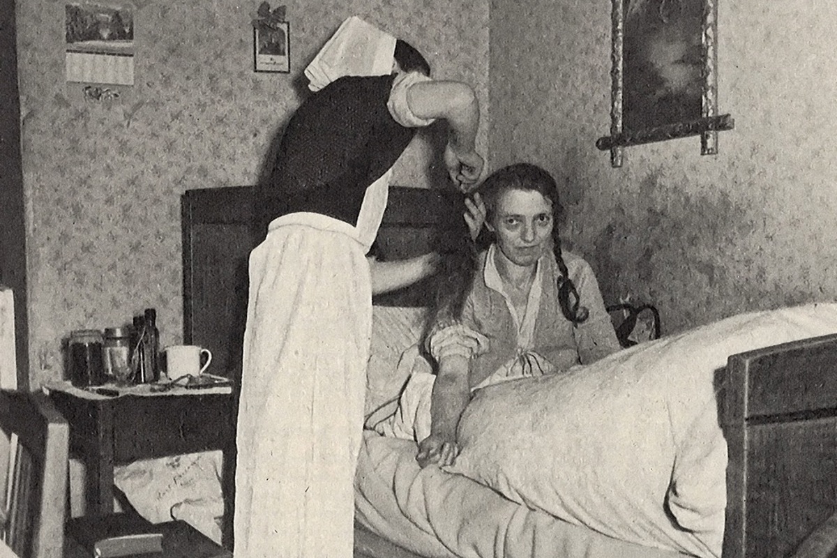 Eine Gemeindeschwester, die eine Patientin 1948 zu Hause pflegt.