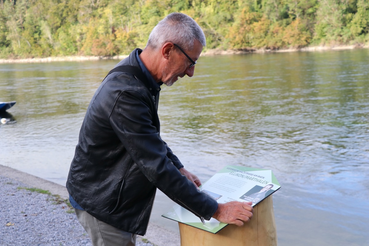 Daniel Stotz befestigt die Infotafel an der hölzernen Stele direkt bei der Anlegestelle der Fähre.