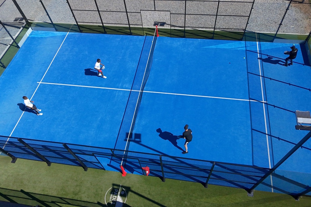 Padel gleicht dem Tennis, wird aber auf einem kleineren, von Glaswänden und Gittern umzäunten Feld gespielt.