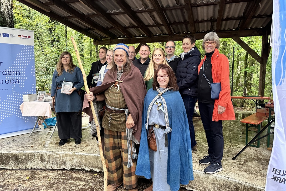 Dieses bunte Völklein besteht aus vier Living-History-Darstellenden in keltischen Gewändern im Vordergrund und hinter ihnen den Redenden: Marcel El-Kassem vom Landesamt für Denkmalpflege (2. v.l.), Rheinaus Gemeindepräsident Andreas Jenni (5. v.l.), Jestettens Bürgermeister Dominic Böhler, und seitens des Naturparks Schaffhausen Pia Sulser, Christoph Müller, Nadja Hallauer (zugleich Vertreterin der Hochrheinkommission) sowie Exkursionsleiterin Sylvia Baumgart.